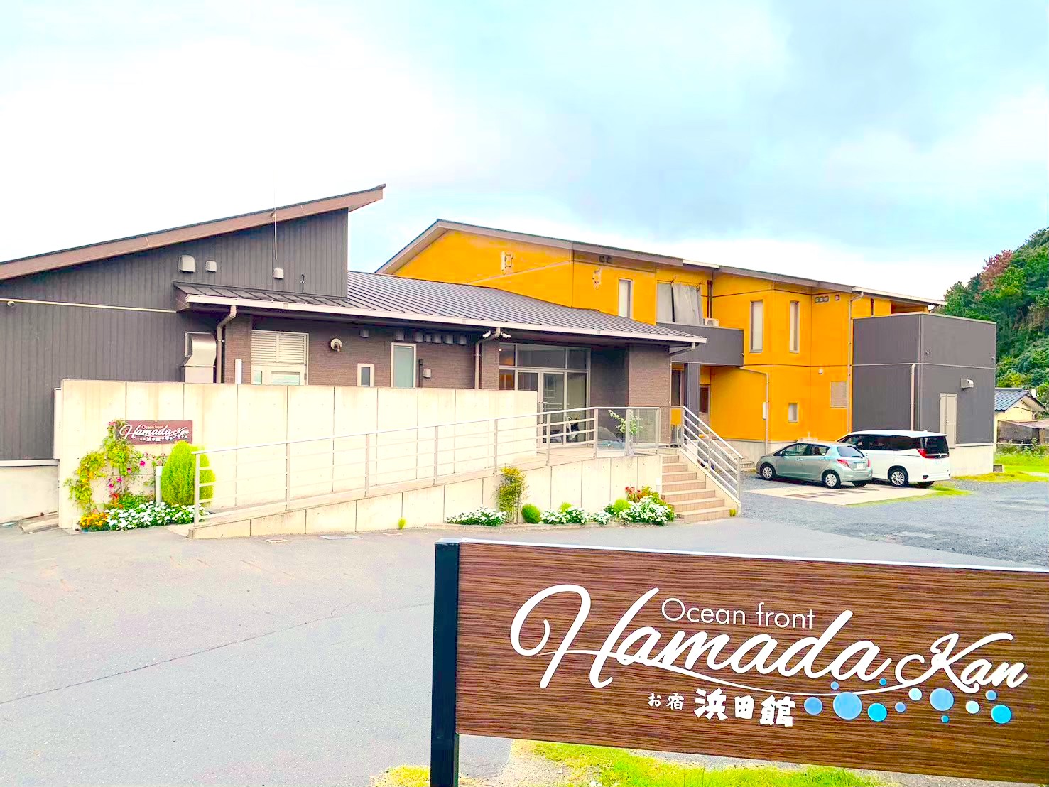オーシャンフロントお宿浜田館の外観と看板