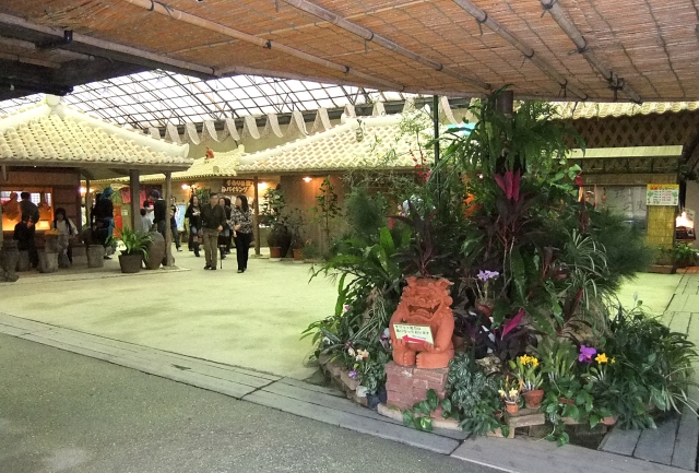 琉球村の売店エリアと植物に囲まれたシーサーの装飾
