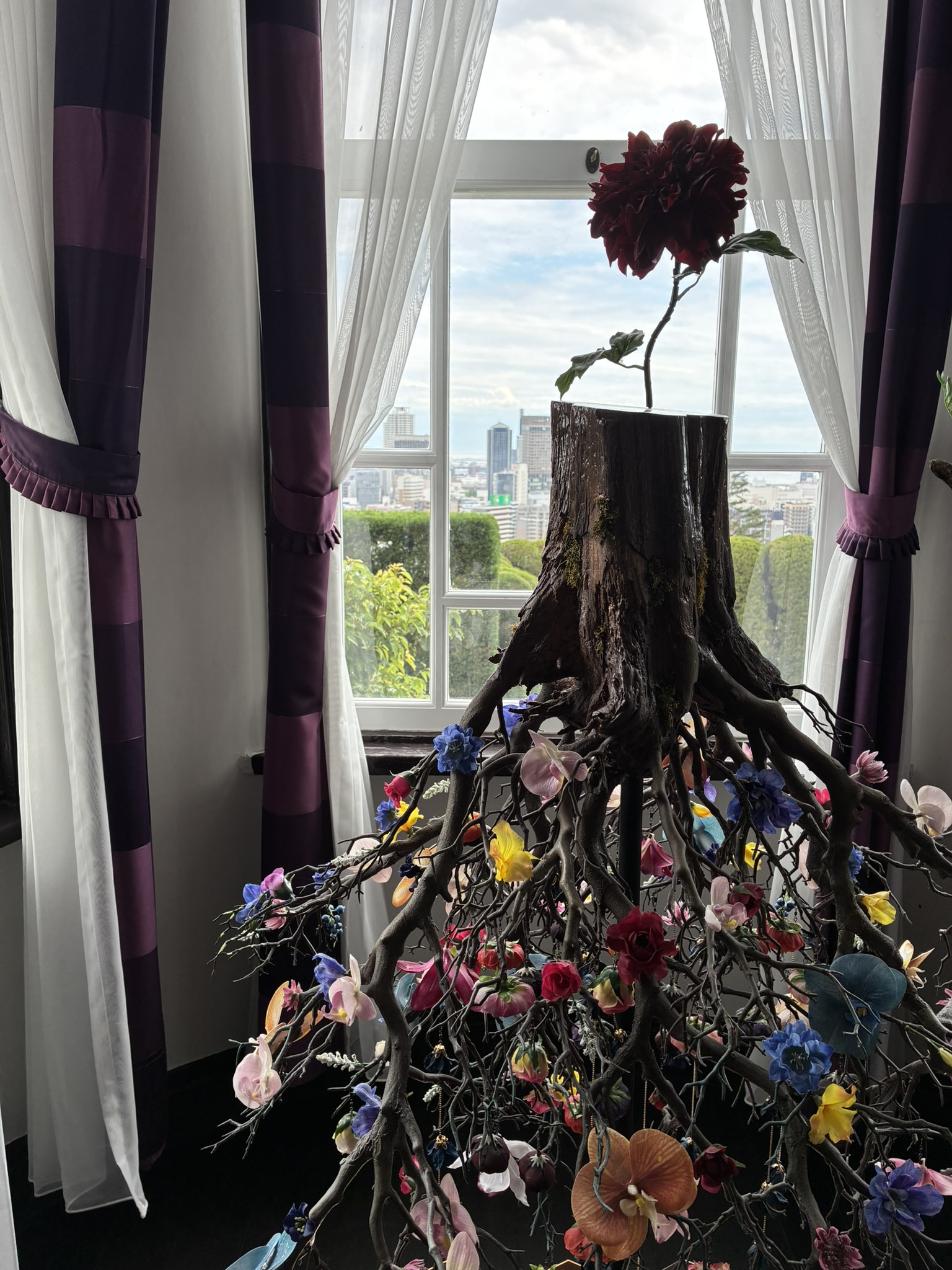 うろこの家の窓辺に飾られた花の展示と神戸の景色