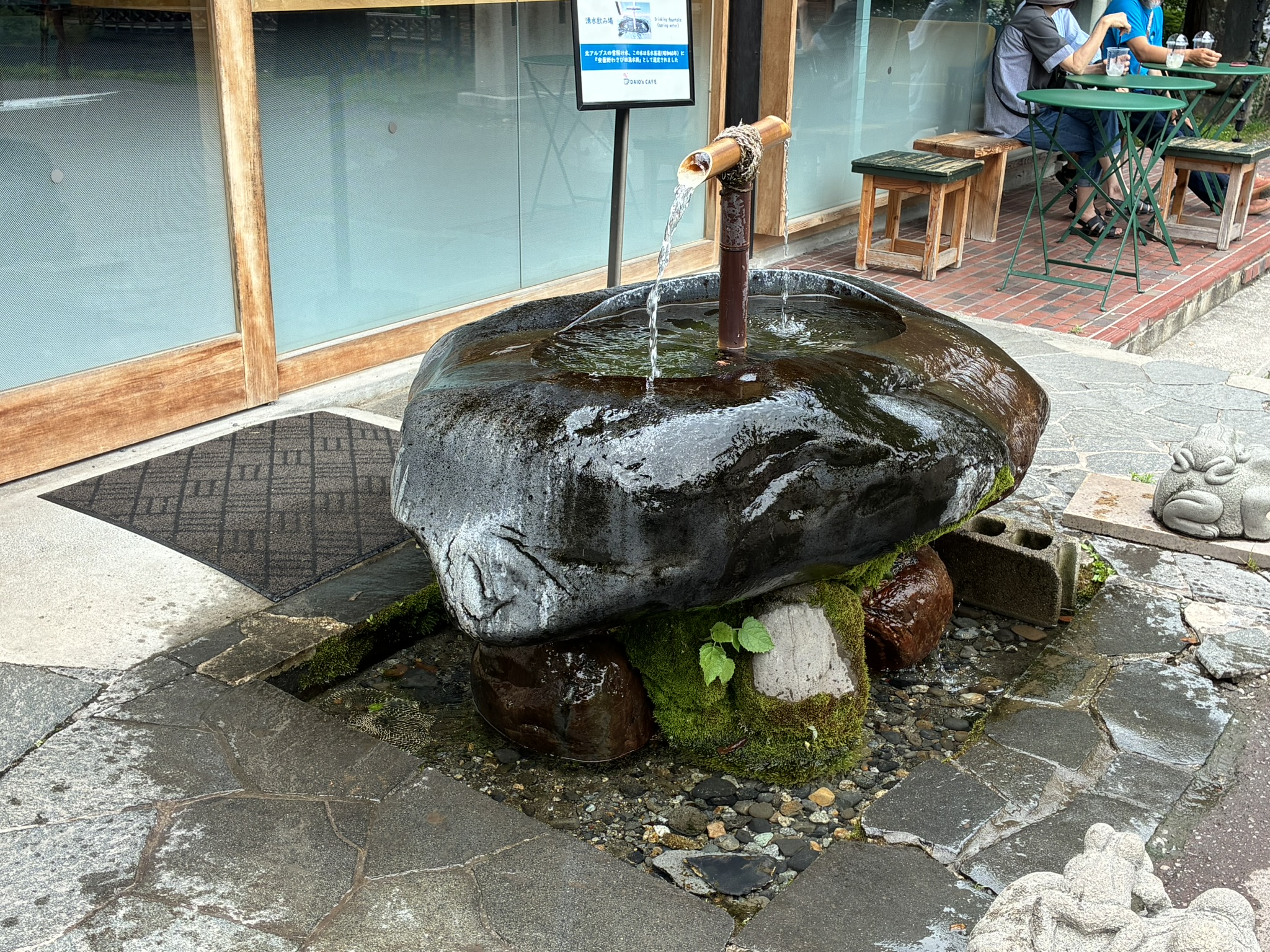 大王わさび農場内で竹筒から水が流れる湧き水の水場