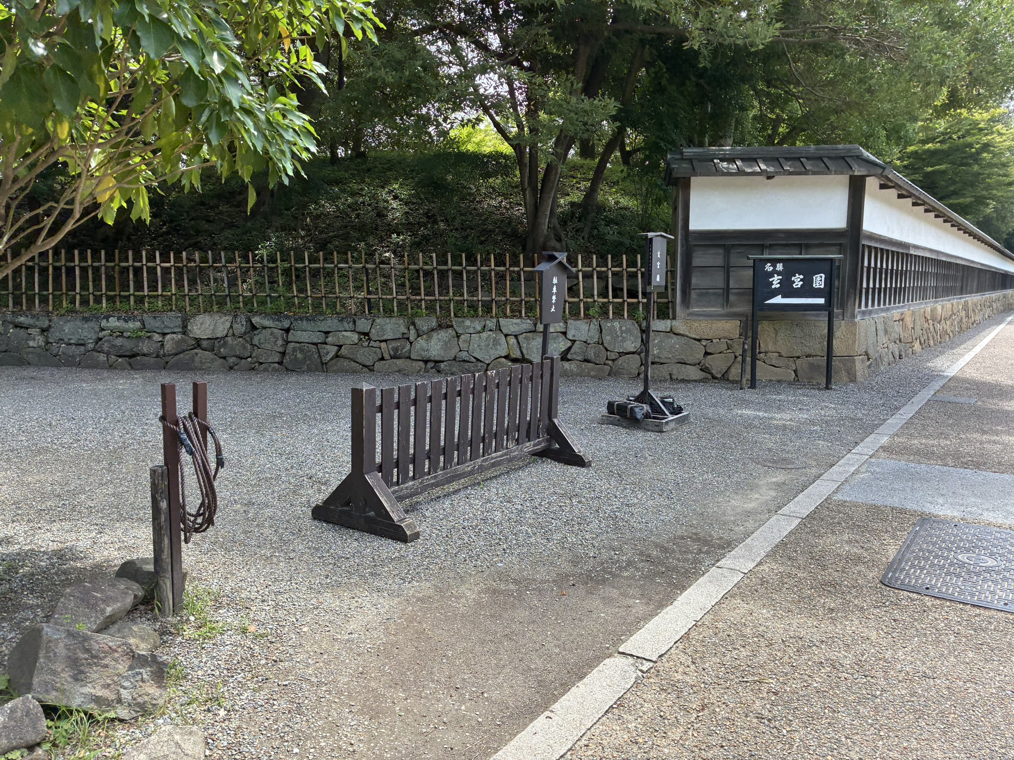 白壁沿いに立つ名勝玄宮園の案内看板