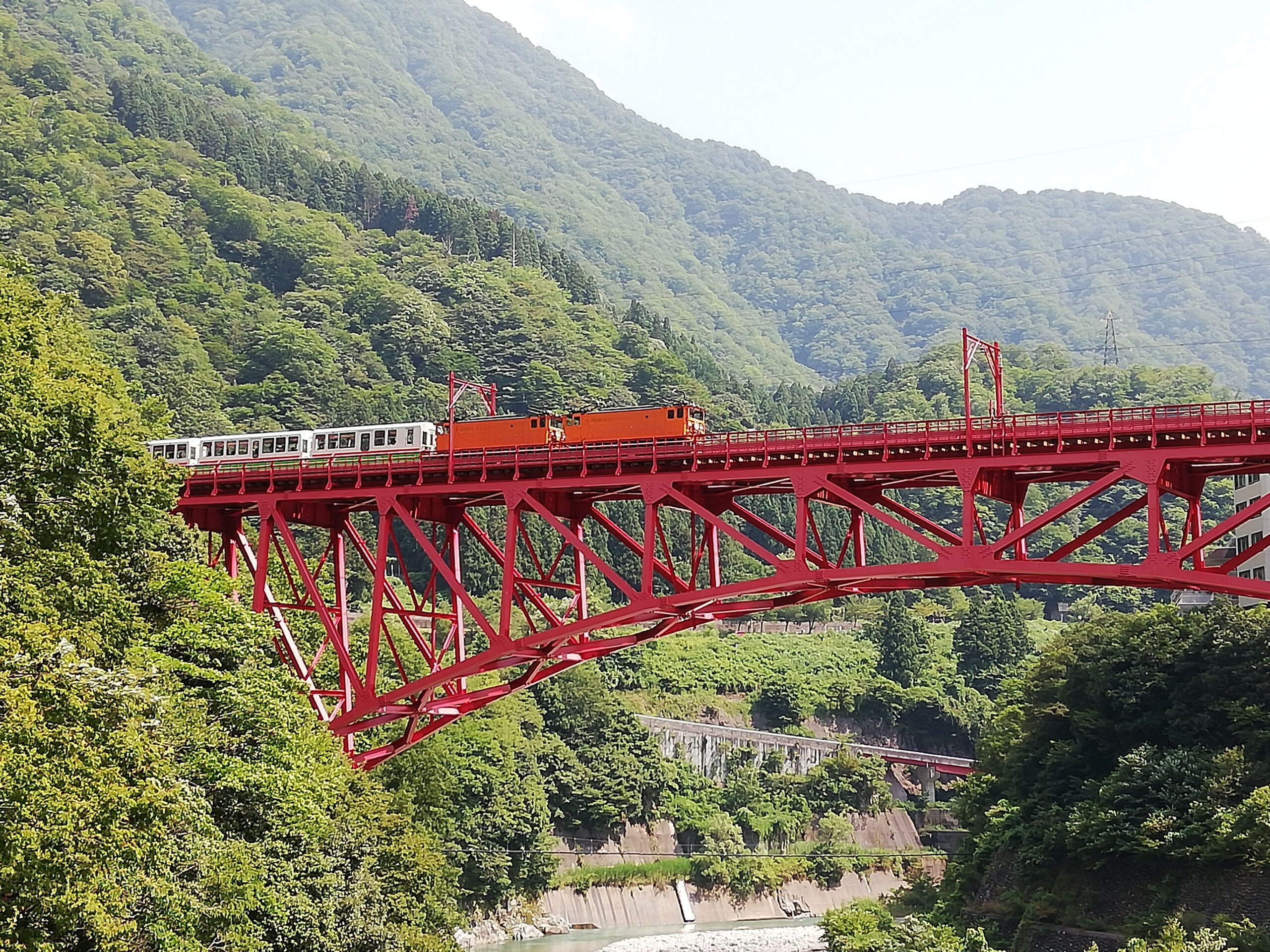 黒部峡谷鉄道のトロッコ電車が新山彦橋を渡る風景