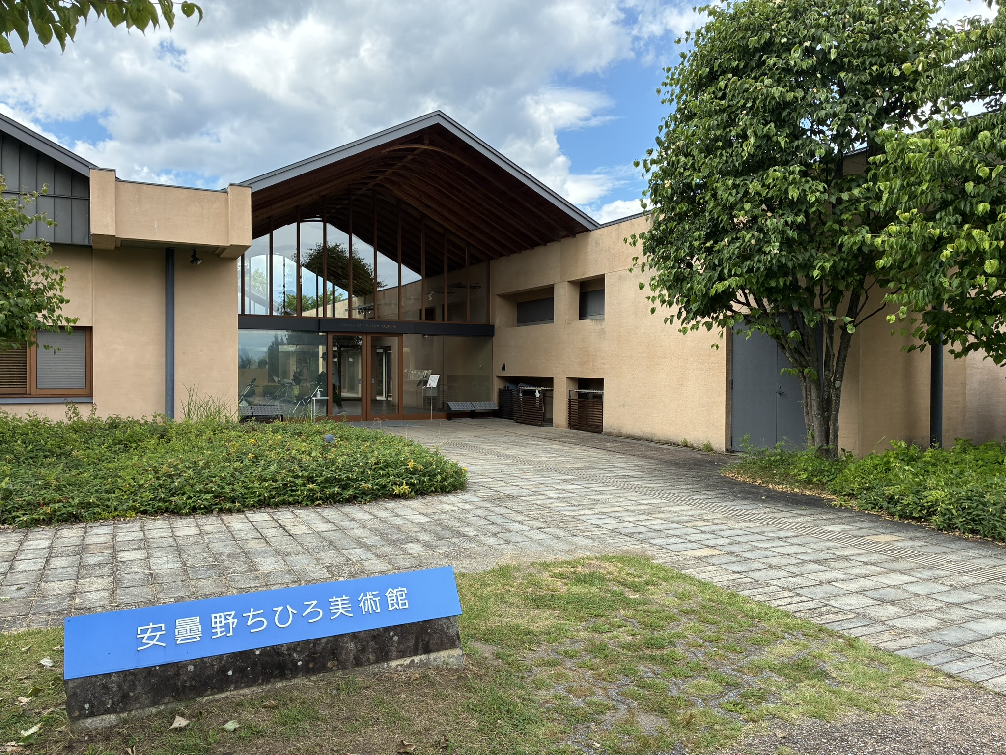 安曇野ちひろ美術館の入口外観と青い施設名看板