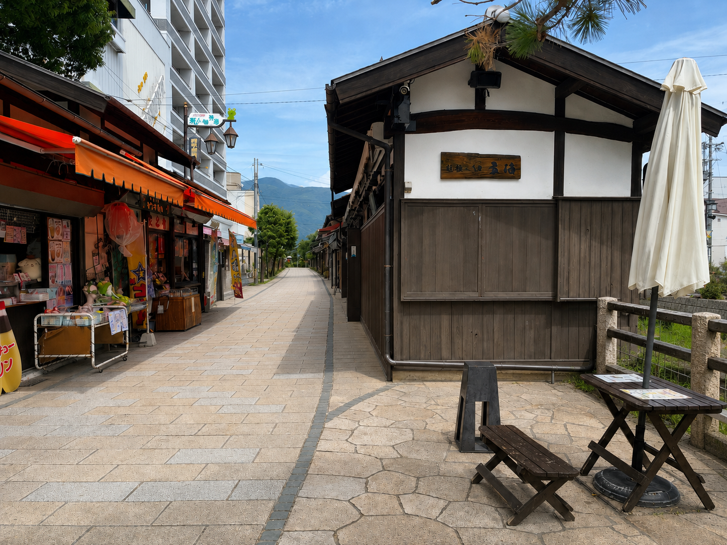 松本のなわて通りに並ぶ長屋風の店舗と奥に見える山並み