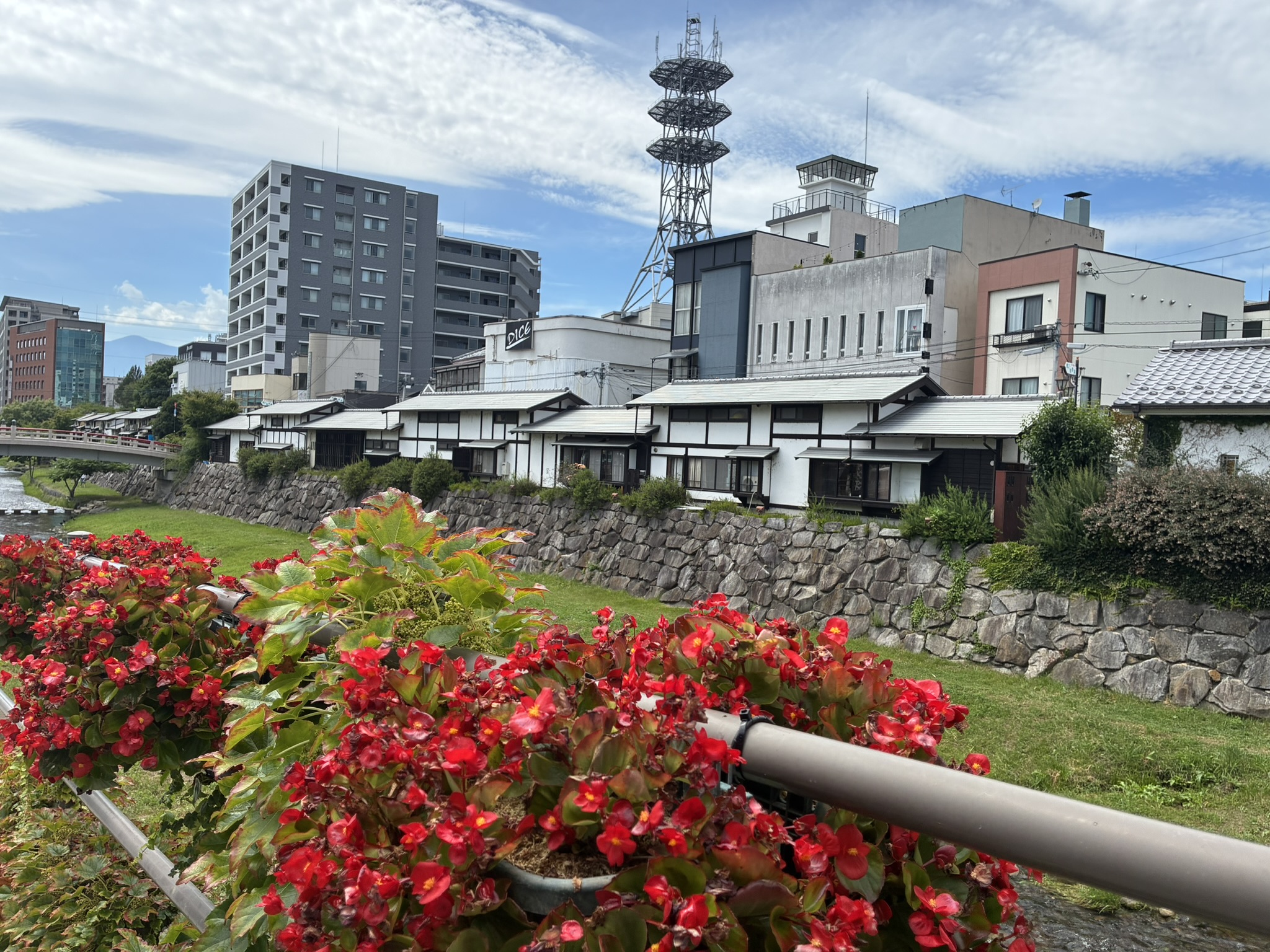 赤い花のプランターと蔵造りの建物が並ぶ松本中町通り