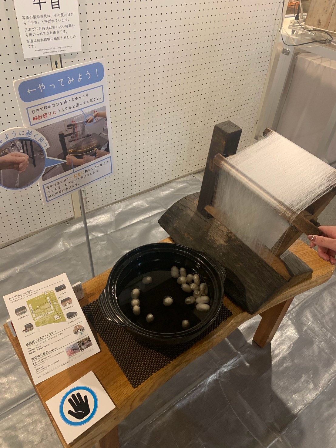 富岡製糸場で繭から糸を取る体験をしている様子