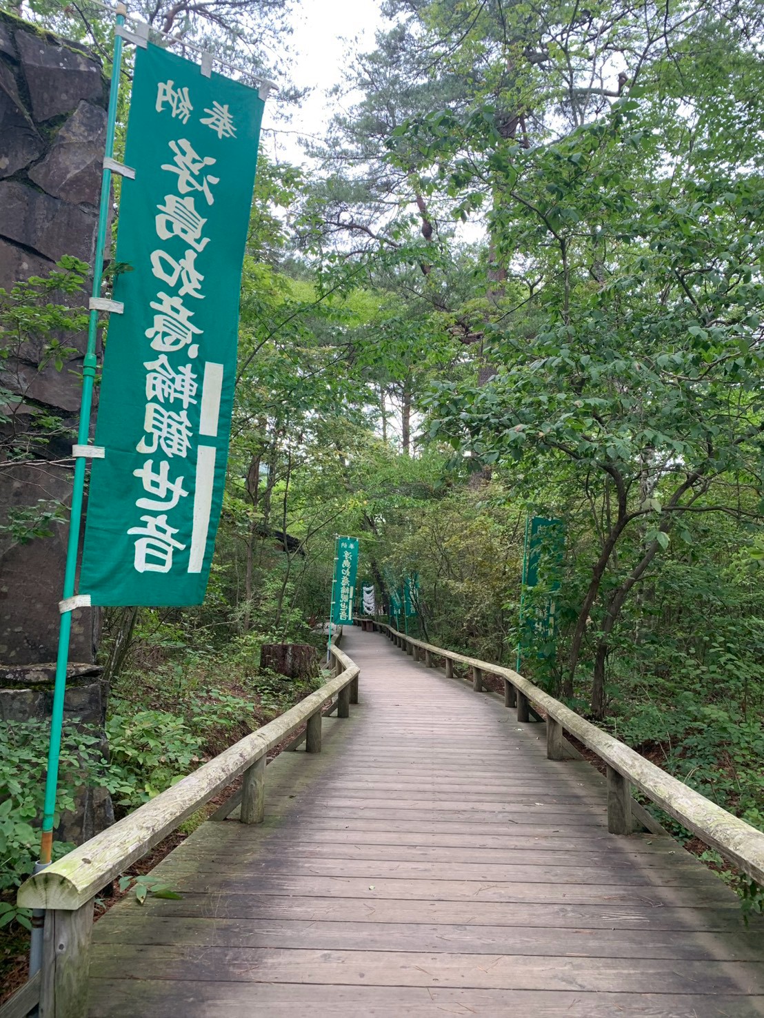 観音の旗が立つ吹割渓谷の木道と周囲の木々